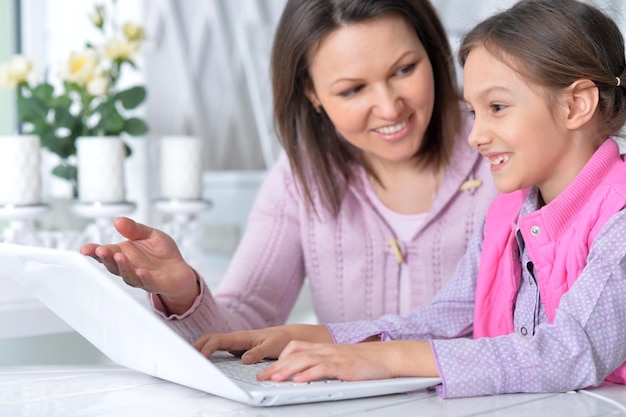 Madre con hija usando laptop