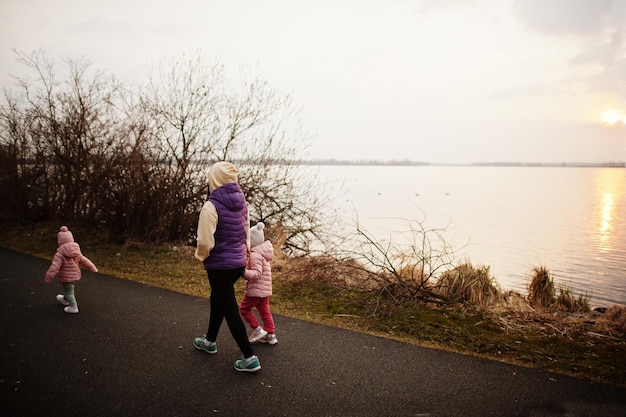 Madre con hijas caminando por el sendero junto al lago