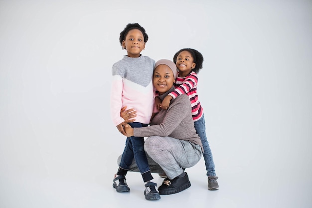 Madre con hijas sonriendo y abrazándose en el estudio