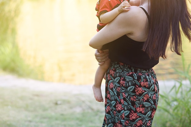 Madre con hijo en brazos en el parque con espacio para copiar y enfoque selectivo