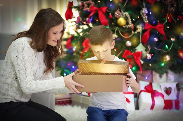 Madre con hijo cerca del árbol de Navidad