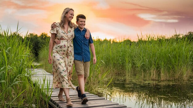 una madre y un hijo están caminando por un paseo marítimo frente a un lago