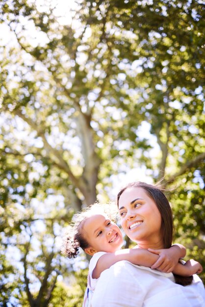 Madre, hijo y familia al aire libre para un paseo a cuestas en verano con felicidad, amor y cuidado Mujer o madre y niña jugando juntos en el parque natural para disfrutar de tiempo de calidad de aventura y libertad con espacio