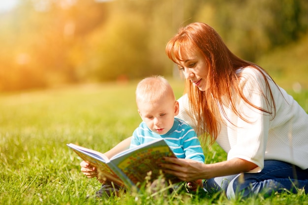 Madre, con, hijo, libro de lectura, en el estacionamiento