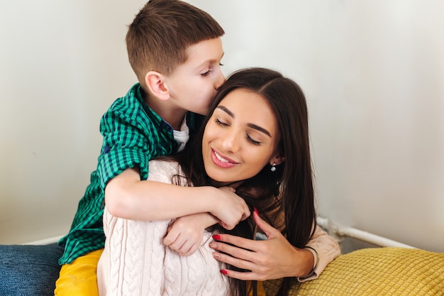 Madre con hijo sonriendo y abrazando en casa