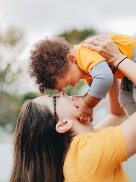 Foto madre y hijo sonrientes abrazándose al aire libre