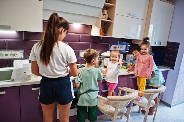 Madre con hijos cocinando en la cocina momentos infantiles felices