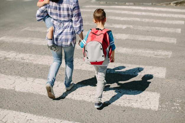 Foto madre con hijos en el cruce de peatones