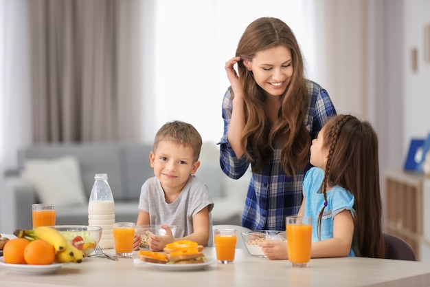 Madre con hijos desayunando en la cocina