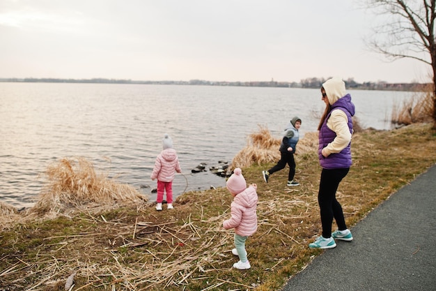 Madre con hijos en la orilla del lago.