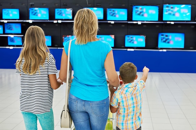 Madre con hijos en la tienda de tv