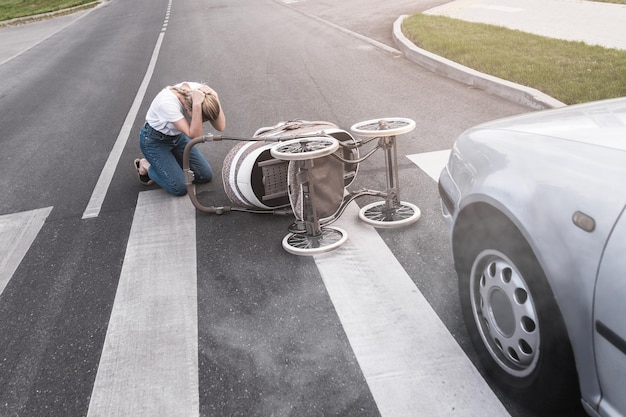 Foto madre horrorizada en el cruce de peatones después de un accidente automovilístico cuando un vehículo golpea su cochecito de bebé