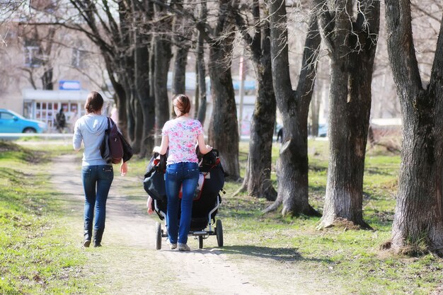 Madre joven con cochecito en el parque