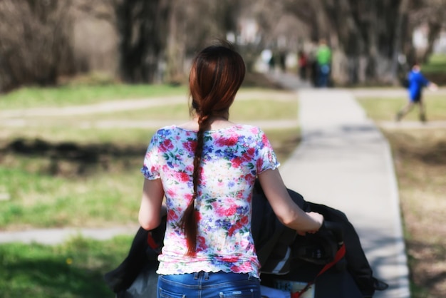 Madre joven con cochecito en el parque