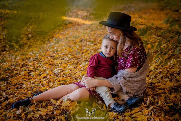Madre joven feliz jugando con el bebé en el parque de otoño con hojas de arce amarillasFamilia caminando al aire libre en otoño Niño pequeño con su madre jugando en el parque en otoño