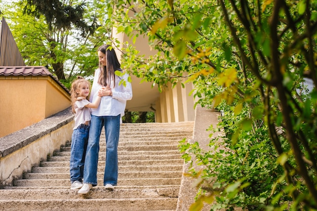 Una madre joven con una hija pequeña baja las escaleras.