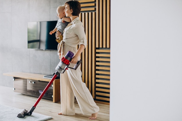 Foto madre joven con hijo pequeño limpiando en casa