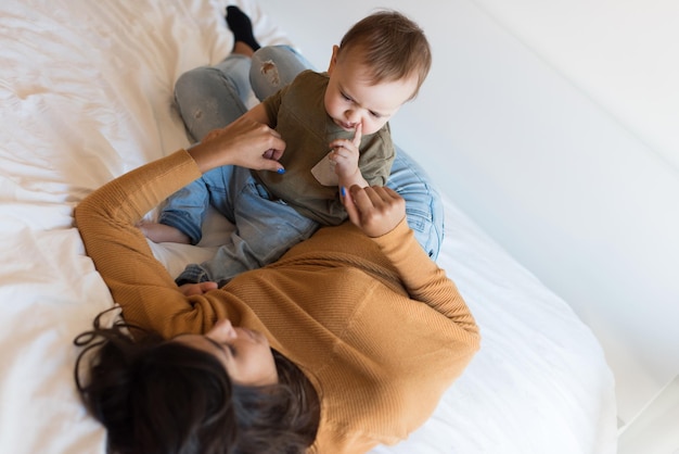 Madre joven jugando con un niño pequeño en casa