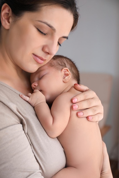 Foto madre joven con lindo bebé en casa