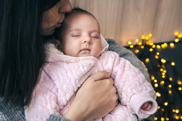 Una madre joven con una niña recién nacida en brazos