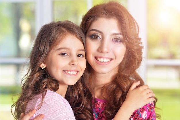 Foto madre joven que abraza a la pequeña hija