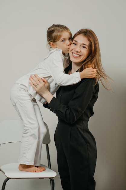 Madre joven con su hija en una silla