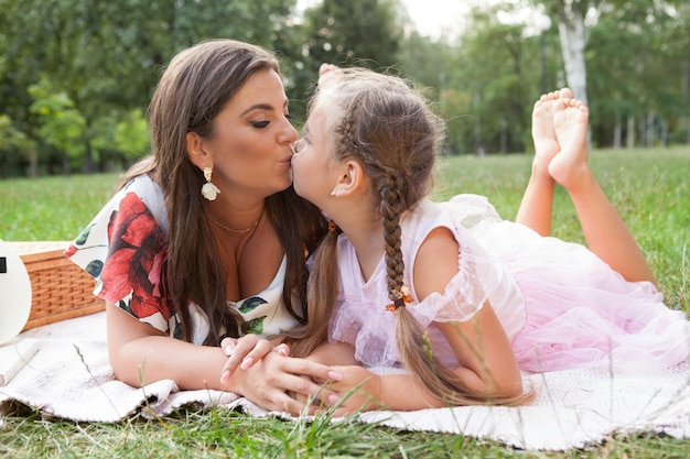 Madre joven con su pequeña hija en un picnic