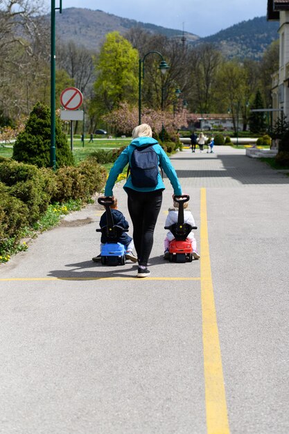 Madre juega con sus hijos con coche de juguete