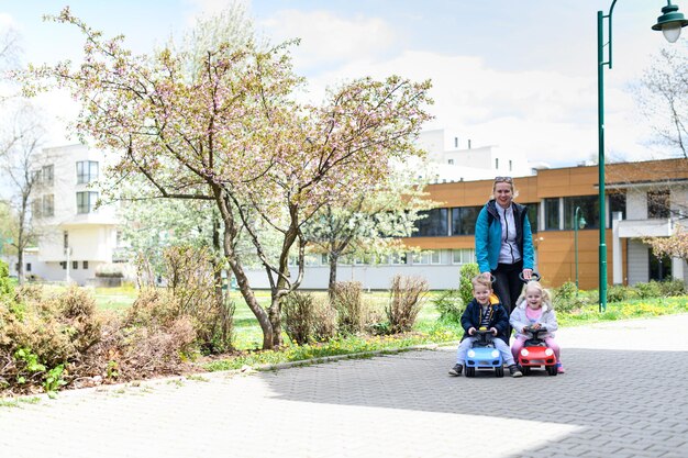 Madre juega con sus hijos con coche de juguete