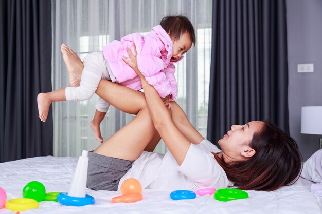 madre jugando con su bebé en una cama