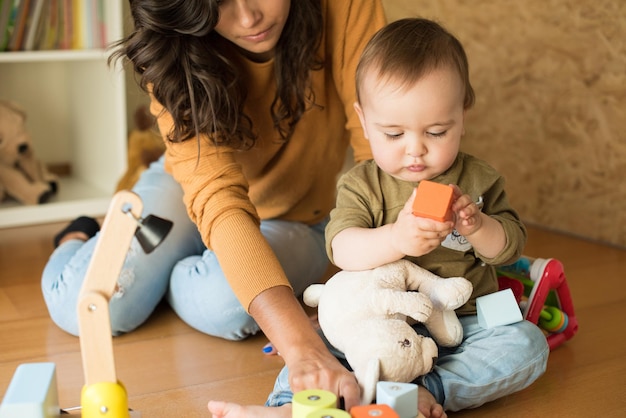 Foto madre jugando con su bebé - concepto de métodos educativos