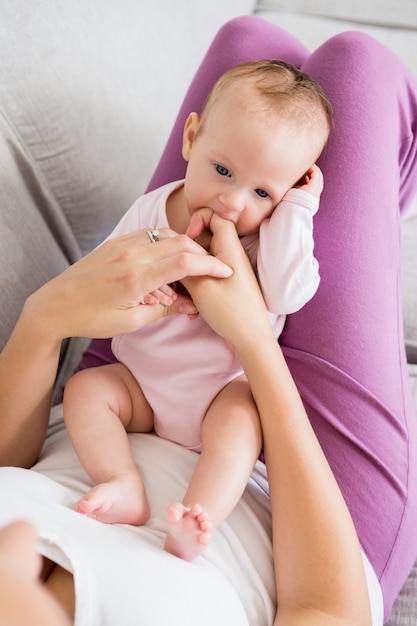 Madre jugando con su bebé en el dormitorio