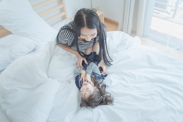 Madre jugando con su hija en la habitación de los niños.