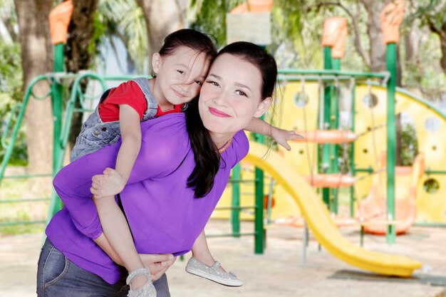 Madre jugando con su hija en el patio de recreo