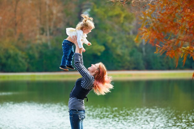 Madre jugando vomitando niña en un lago