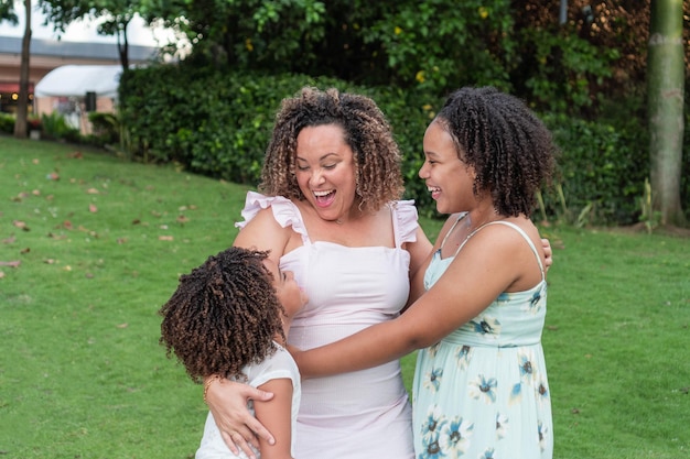 Madre latinoamericana con sus hijas sonriendo juntas