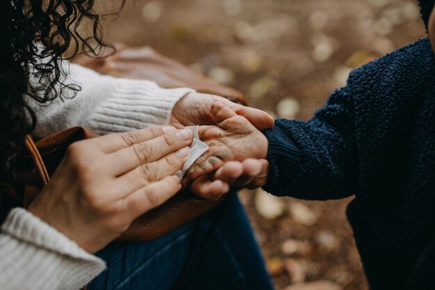 Madre limpiando las manos sucias de su hijo