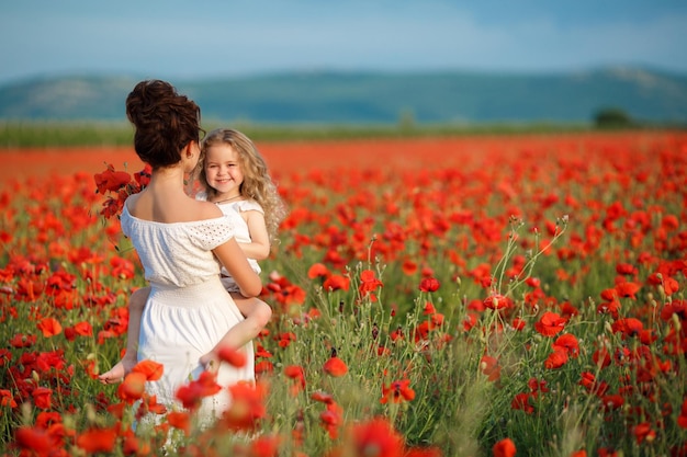 madre con una linda hija en el campo de amapolas