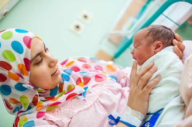 madre llevando a su hijo en cama de hospital