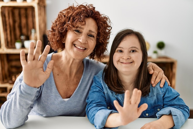 Madre madura e hija con síndrome de down en casa tomando una foto