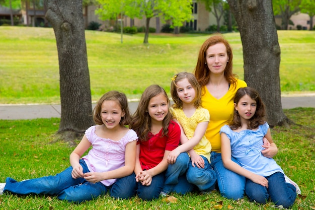 Madre maestra con hijas pupilas en parque infantil