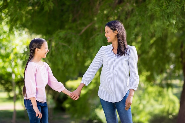 Madre de la mano de su hija en el parque