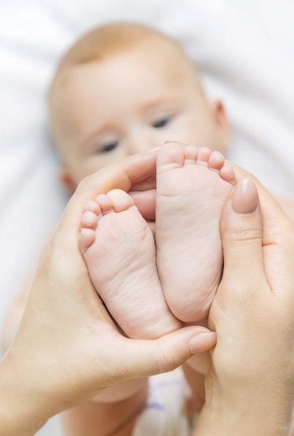 La madre mantiene la pierna del bebé en casa.