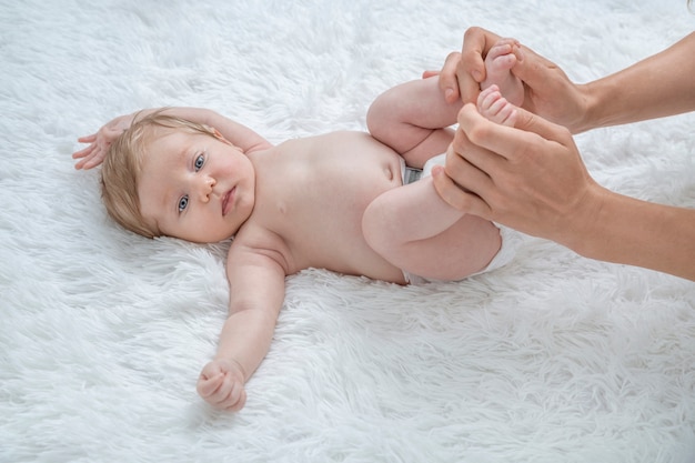 Foto madre masajeando la barriga de su bebé recién nacido.