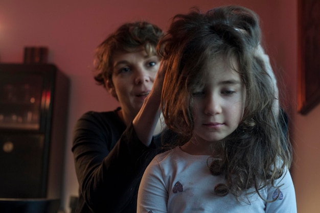 Foto madre masajeando la cabeza de la niña en casa