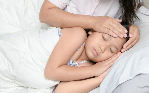 Madre midiendo la temperatura del niño enfermo.