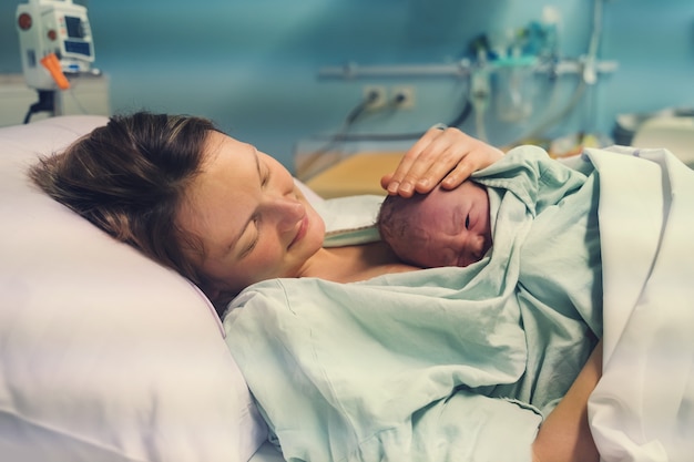 Foto la madre y el nacimiento del niño recién nacido en el hospital de maternidad mamá abrazando a su bebé recién nacido después del parto