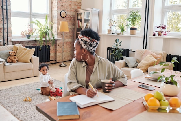 Madre negra trabajadora mirando a su hijo