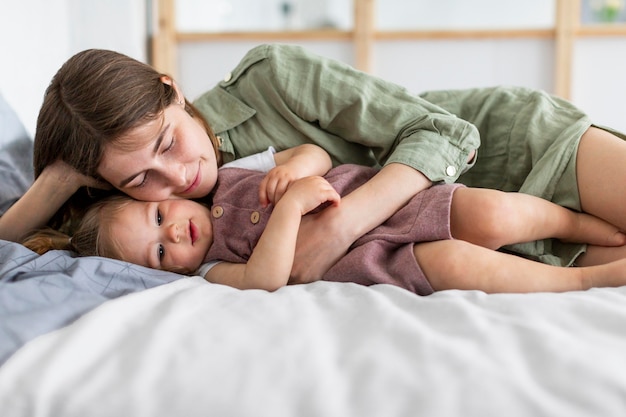 Madre y niña acostada en la cama