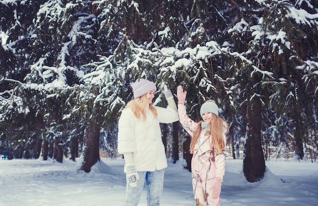 Madre y niña en el bosque de invierno